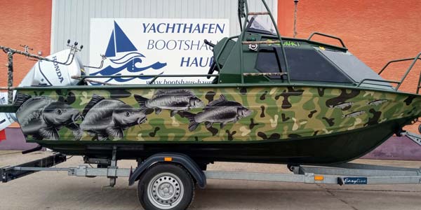 Bateau à carpes pelliculé avec des autocollants de carpes.